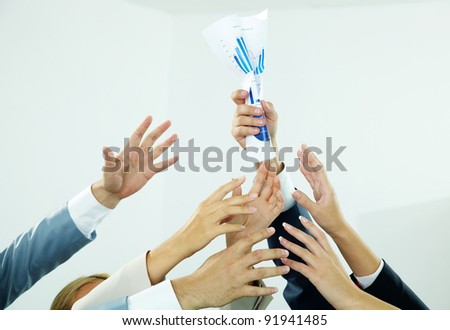 Image of several human hands trying to get  paper from male hand