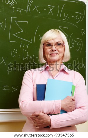stock photo Portrait of mature teacher with copybooks looking at camera 