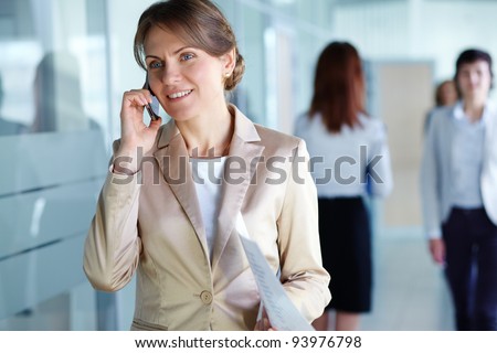 Image of agent with paper speaking on the phone in working environment