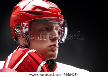 Portrait of a hockey player against black backround