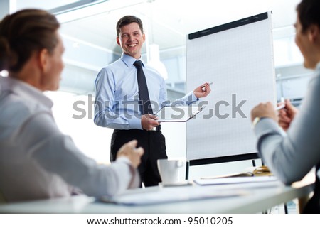 Cheerful businessman discussing a new business project with the members of his team