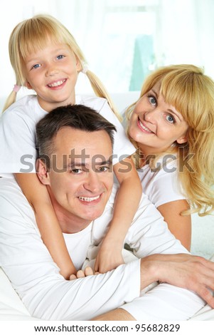Family of three spending time together and smiling at camera