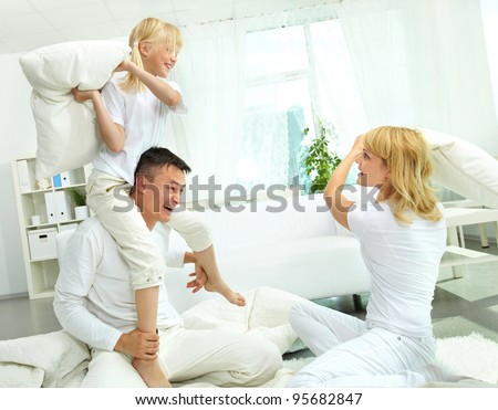 Cheerful family having a lot of fun fighting pillows