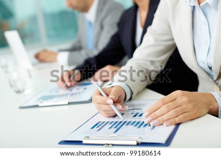 Business people sitting at the table and analyzing graphs