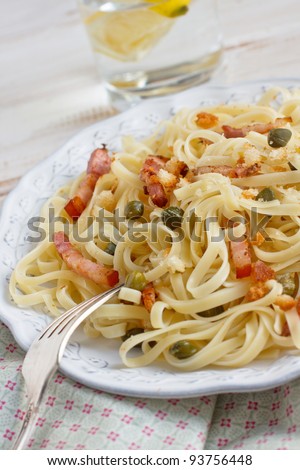 Fresh homemade pasta with bacon, caper and bread crumbs
