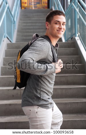 young male college student at school with backpack
