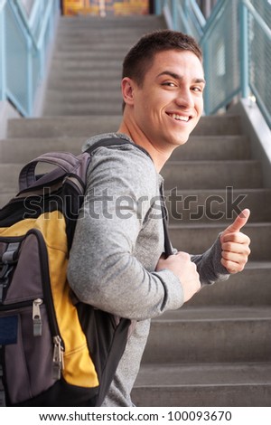 young male college student at school with backpack
