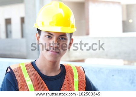 portrait of a young asian construction worker standing outside