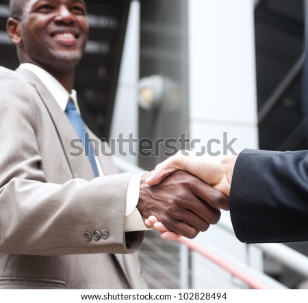closeup of African American businessman shaking hands with caucasian businessman