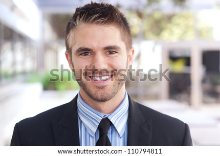portrait of a handsome young businessman standing outside office
