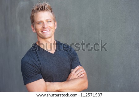 Portrait of a happy young man looking at camera, standing outside