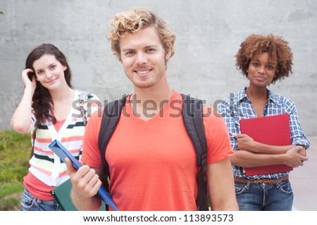 Happy group of students holding notebooks outdoors