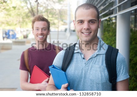 pair of happy young male students on campus