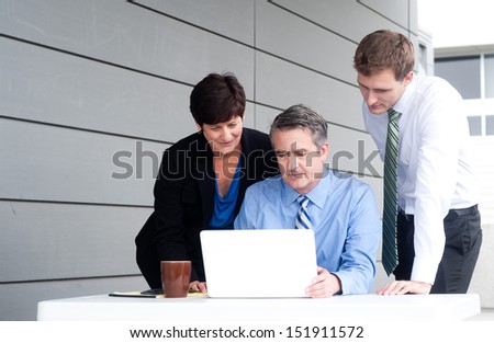 Happy working business team with computer in modern office