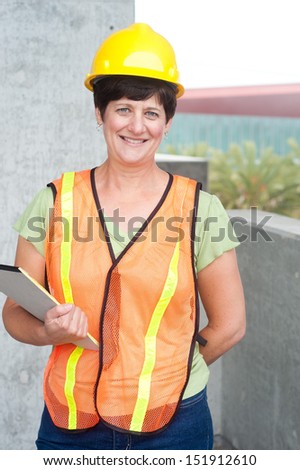 Woman construction worker in hard hat taken outside