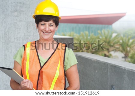 Woman construction worker in hard hat taken outside