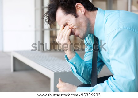 Frustrated businessman sitting on a bench