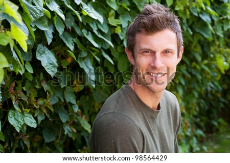 portrait of a handsome young man smiling outside