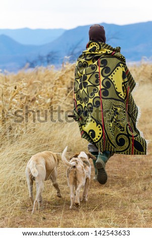 Unidentified Basotho man with 2 dogs wearing traditional blanket - Lesotho, Africa