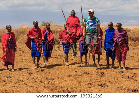 AFRICA, KENYA, MASAI MARA - SETPEMBER 10: Masai warriors show traditional dance jumps to a tourist near Masai Mara National Park Reserve, September 10,2013,Kenya