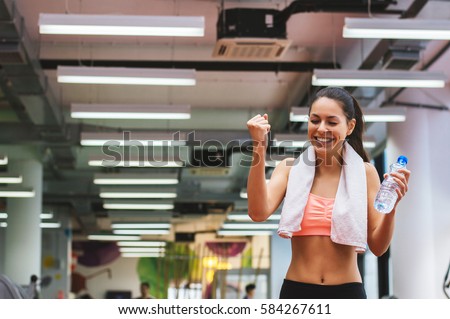 Happy sports woman celebrating her success in gym