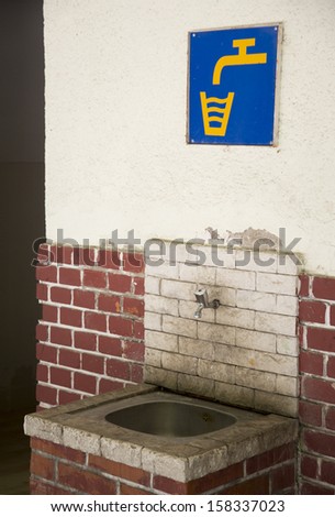 Old public sink, with sign above it: drinking water