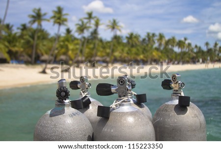 Scuba diving tanks with blue ocean and palm tree background.