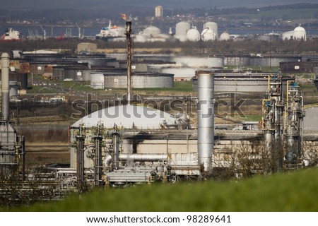 Chemical plant with flare chimneys and heat haze.