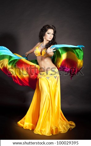 beautiful slim woman belly dancer sexy arabian turkish oriental professional artist in carnival shining costume with long healthy glossy hair and veil. exotic star of bellydance. spring-summer