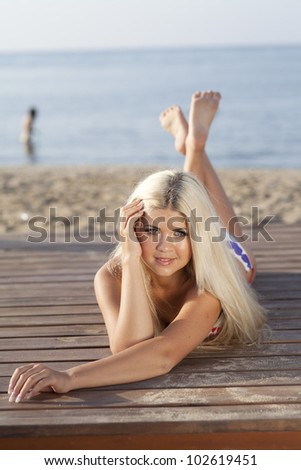 Slim girl resting at the beach vacation holidays happy woman enjoying summer sun. Romantic girl dreaming at sea coast spa - health care. Beautiful bikini model in swimwear at exotic carribean resort