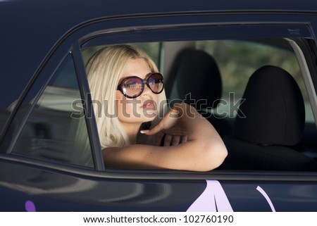 happy young woman in car smiling enjoying car road trip travel vacation. Driving. sexy lady with glasses blonde healthy hair in automobile . spring - summer portrait of tourist girl