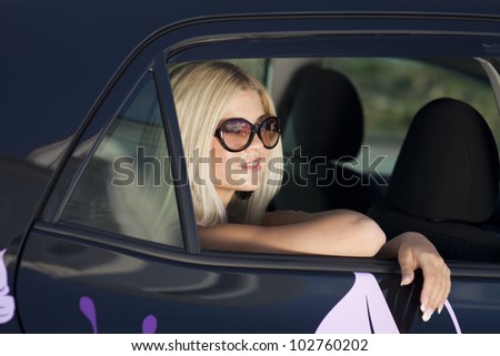happy young woman in car smiling enjoying car road trip travel vacation. Driving. sexy lady with glasses blonde healthy hair in automobile . spring - summer portrait of tourist girl