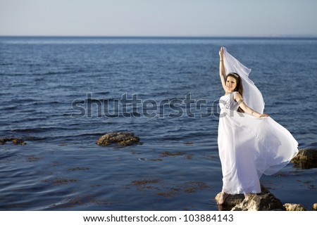 beautiful slim bride in wedding dress on sunset beach near sea. young woman in Greek  goddess style with diamond tiara and jewelery. Fashion stylish romantic girl with glossy hair. Spring - summer