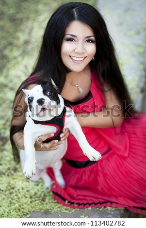 happy young smiling woman in autumn park with funny little dog. beautiful girl in stylish red dress relaxing on nature. gorgeous brunette romantic  lady resting and having fun. positively thinking.