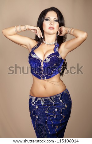 Gorgeous woman bellydancer. sexy oriental girl. slim and beautiful arabian professional artist in carnival shining costume with long glossy hair. exotic star of bellydance. dancing girl brunette