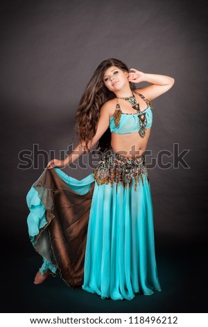 Little girl bellydancer in traditional oriental costume. Beautiful arabian adorable toddler child with long curly hair. Portrait of baby artist in carnival oriental dress. exotic star of bellydance.