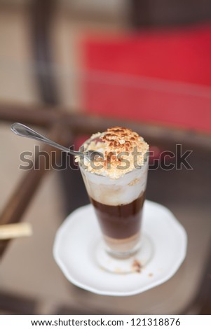 Cappuccino or latte coffee. fresh tasty cocoa cocktail in restaurant for dinner. Frothy, layered cappuccino in glass mug with vanilla cookies cinnamon sprinkled on top. italian creamy Latte in cafe