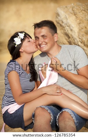 Loving playful couple on sand beach at honeymoon travel hugging and kissing in summer. Happy smiling family together in moment of happiness. man and woman on date on tropical island on Valentines day