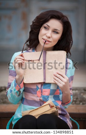 Beautiful woman read book at street. attractive woman girl with books in city park. happy pretty woman with book. smiling student woman reading book. University education. Romantic lady and sunglasses