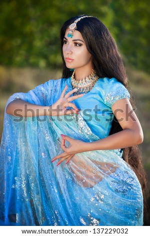 beautiful indian woman bellydancer dancing bollywood dance in sari outdoors. Brunette indian beauty girl artist dancing arabian dance or bellydance with bridal makeup and jewelry. bollywood dancer