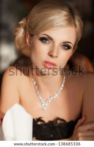 Beautiful sexy woman in restaurant cafe blonde girl rich stylish lady resting at retro villa  hotel with hairstyle makeup jewelry in evening dress. pretty young slim woman in cafe. Happy smiling girl