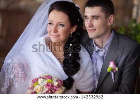 Wedding couple newlywed bride and groom in love at wedding day outdoors. Happy loving couple at bridal day embracing. newlywed with bouquet flowers. Relationship. Smiling wife and husband kiss