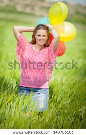 Happy middle aged woman smiling outdoors with balloons in park nature look well. Attractive  middle aged woman on green field. Middle aged woman looking with happy smile. Healthy woman. Woman in love.