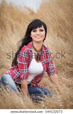 beautiful sexy woman smiling outdoors brunette cowboy girl in jeans on golden hey wheat on nature. Happy cowgirl relaxing in wheat field american model beauty and fashion. Attractive woman on nature.
