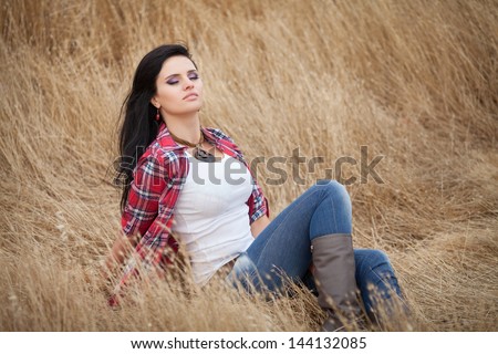beautiful sexy woman smiling outdoors brunette cowboy girl in jeans on golden hey wheat on nature. Happy cowgirl relaxing in wheat field american model beauty and fashion. Attractive woman on nature.