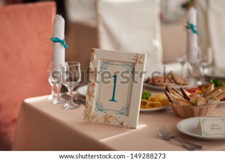 Wedding Table Decoration sea style decor at tropical royal wedding. Stylish wedding table numbers at bridal dinner. Wedding decoration with seashells. wedding picture frames decorated with starfish