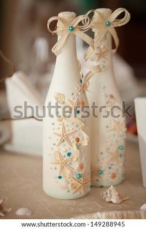 Wedding champagne decoration with seashells starfish at royal wedding diinner. Wedding table decoration at tropical bridal table. thailand wedding. alcoholic drink decorated sea style. wedding decor