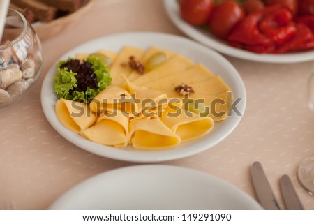 Cheese on plate at restaurant wedding dinner. tasty delicious cheese plate on party table. Cheese slices with fresh herbs