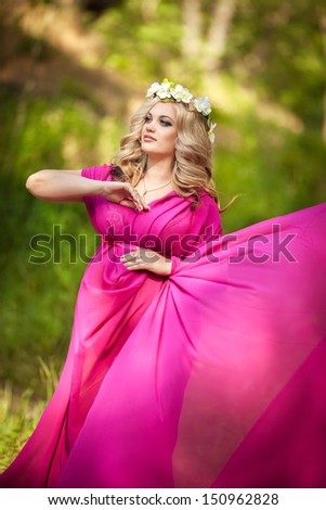 Attractive pregnant woman at nature, pregnancy girl. beautiful pregnant girl outdoors. Happy pregnancy. Happy pregnant woman relaxing in park. Pregnant woman with wreath. Pregnant girl with flowers.