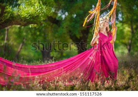 Attractive pregnant woman in park outdoors. Happy pregnancy. Pregnant girl on swing on nature. Romantic pregnant woman in garden. Pregnant woman relaxing. Pregnant woman fairy. Pregnant with wreath